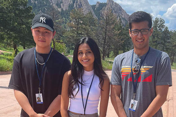 CI Compass Fellows Edward Lin, Mahee Shah, and Raja Ali stand in Boulder, Colorado, on a path in front of mountains in the background.
