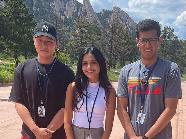 CI Compass Fellows Edward Lin, Mahee Shah, and Raja Ali stand in Boulder, Colorado, on a path in front of mountains in the background.
