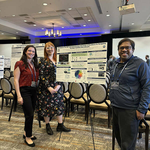 Three people (Nicole Virdone, Christina Clark, and Anirban Mandal) stand in front of posters at NSF RIW.