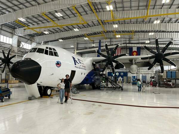 Mark Onders stands with crutches with Ellie Fahey, both CI Compass Fellows in the 2024 Summer Program, in front of an NSF plane at NCAR. / Provided by Mark Onders.