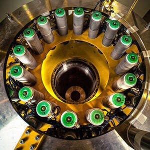 An image shows the NSF MagLab's Tesla 32 superconducting magnet. It is silver, green, and yellow.